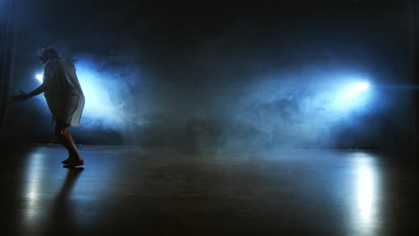 Slow-motion:-female-dancer-on-stage-in-smoke.-Modern-ballet-barefoot-on-stage.